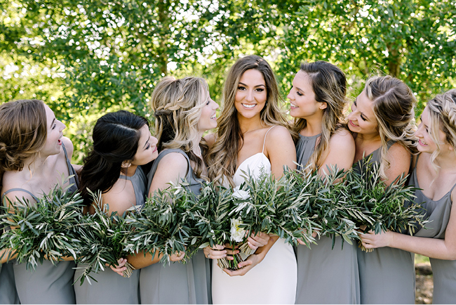 Bridesmaids in soft grey chiffon dresses, and a bride in a gown from Lovely Bride Dallas