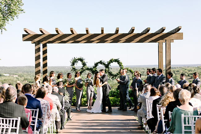 Bride and groom first kiss at Canyonwood Ridge, overlooking the Texas Hill Country