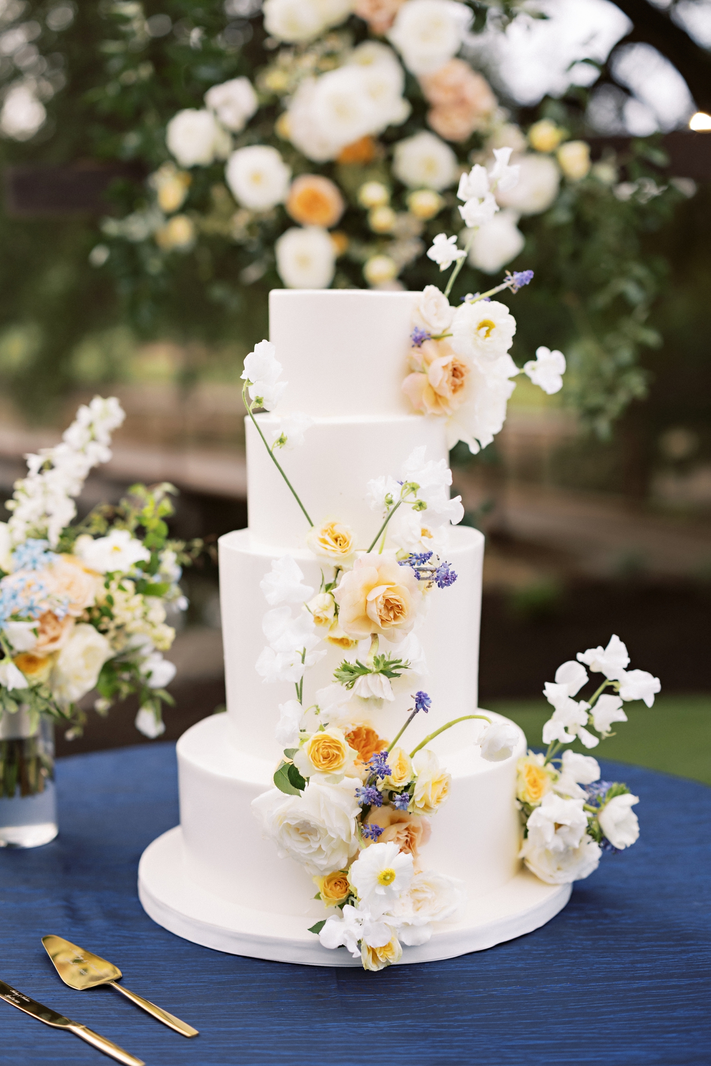 Four tier wedding cake by Simone Lee Bakery with fresh flowers