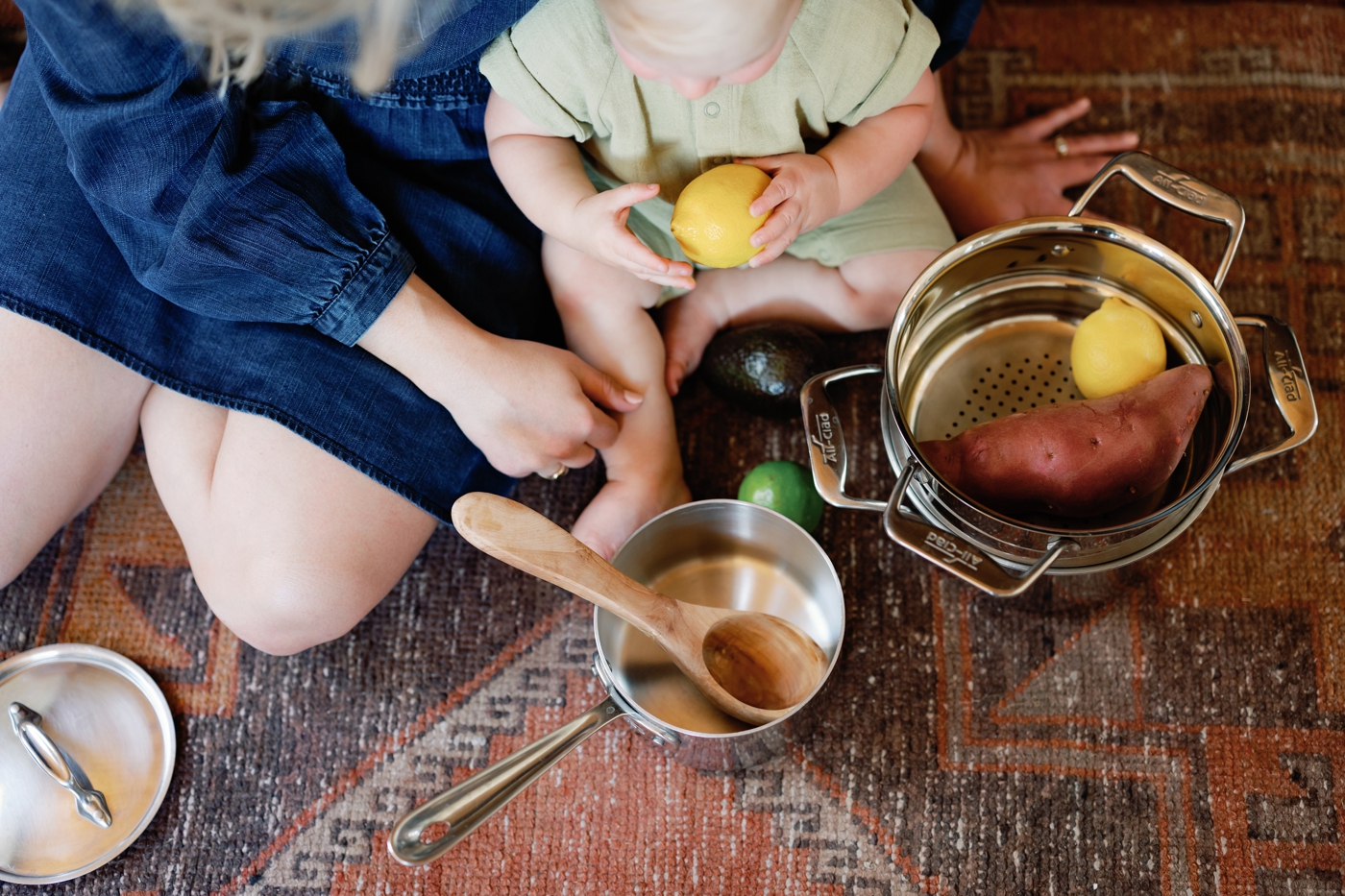 Baby boy with kitchen items, holding a lemon