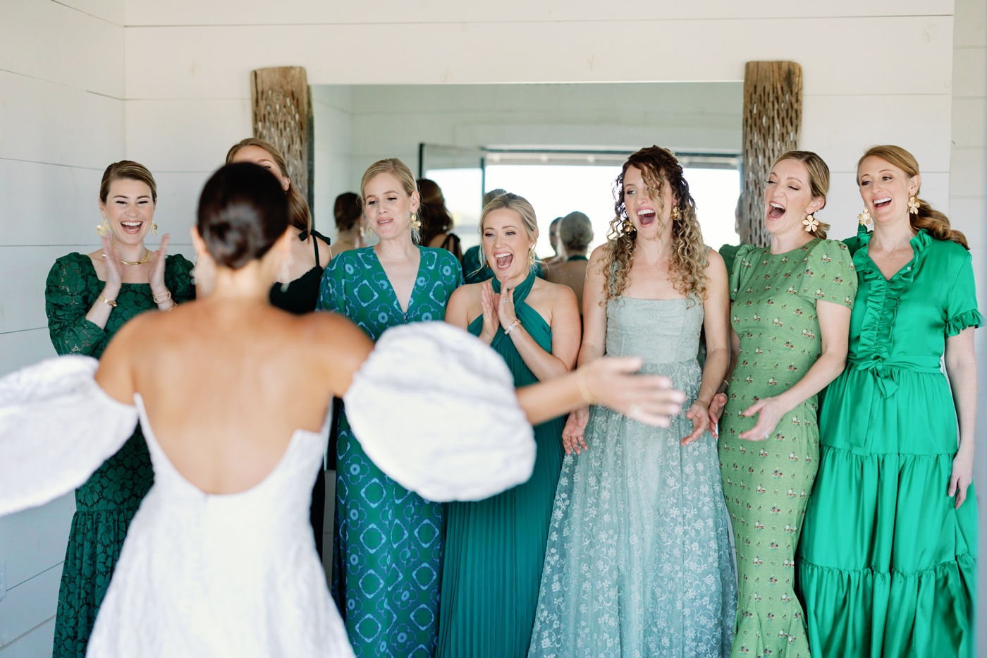Bride showing her bridesmaids her wedding dress, the Melrose gown by Lela Rose, an embroidered ballgown with puff sleeves