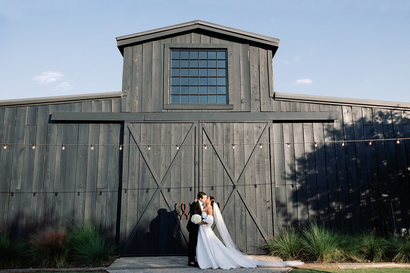 Bride and groom in front of the barn at Two Wishes Ranch