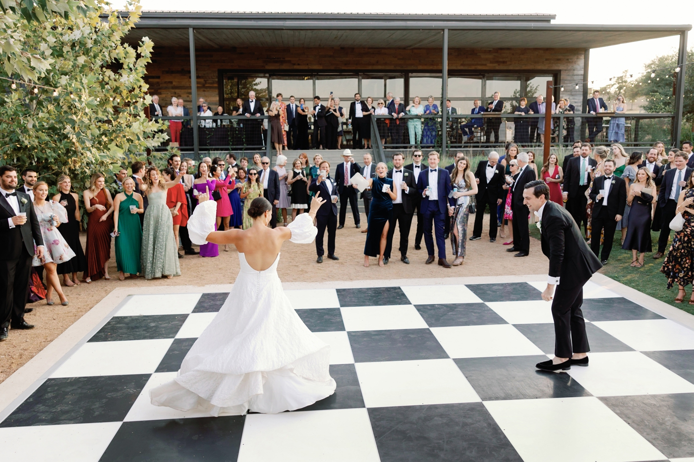 Bride and groom first dance on a checkered dance floor