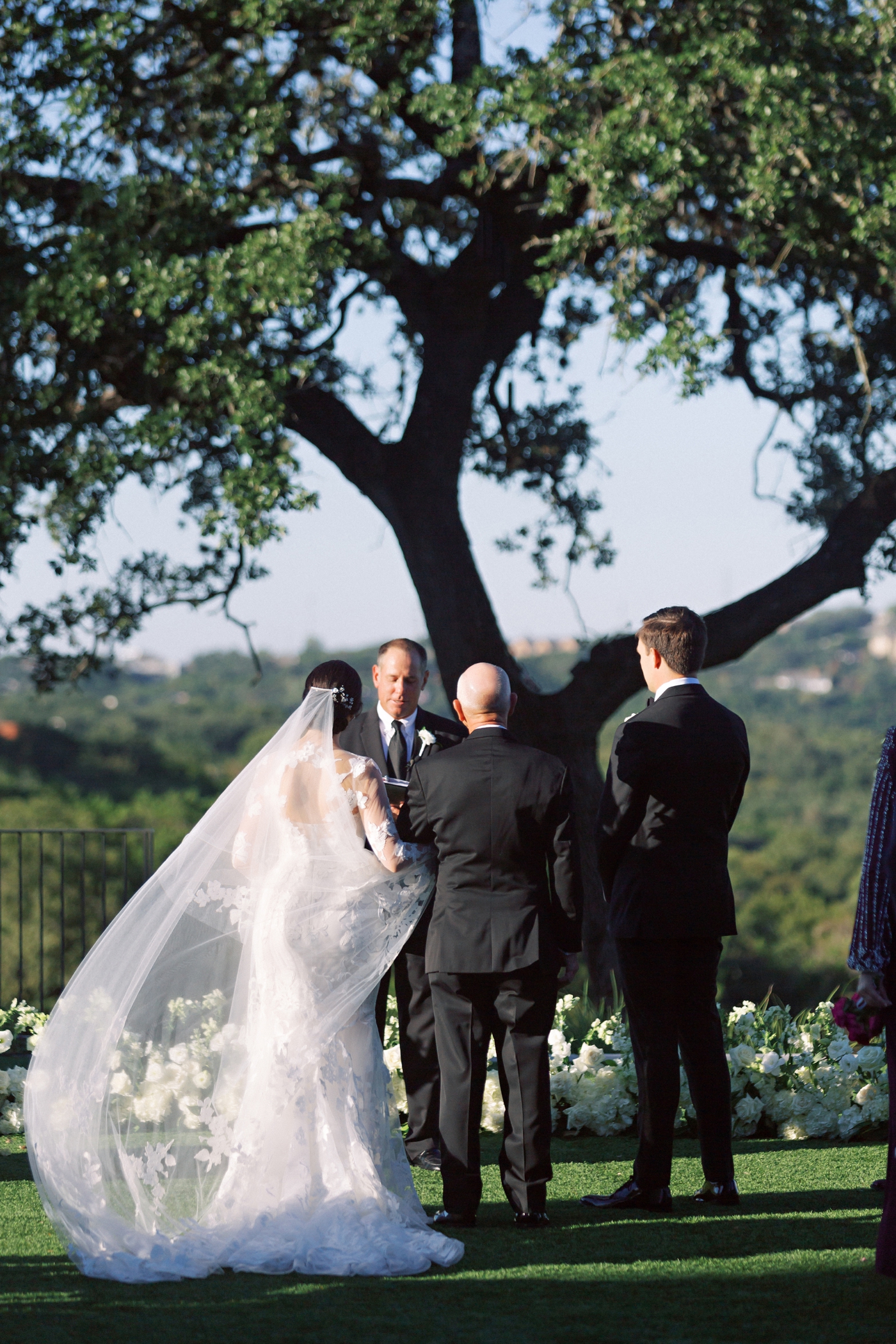 Wedding ceremony on a lawn overlooking the Austin Hill country at Omni Barton Creek