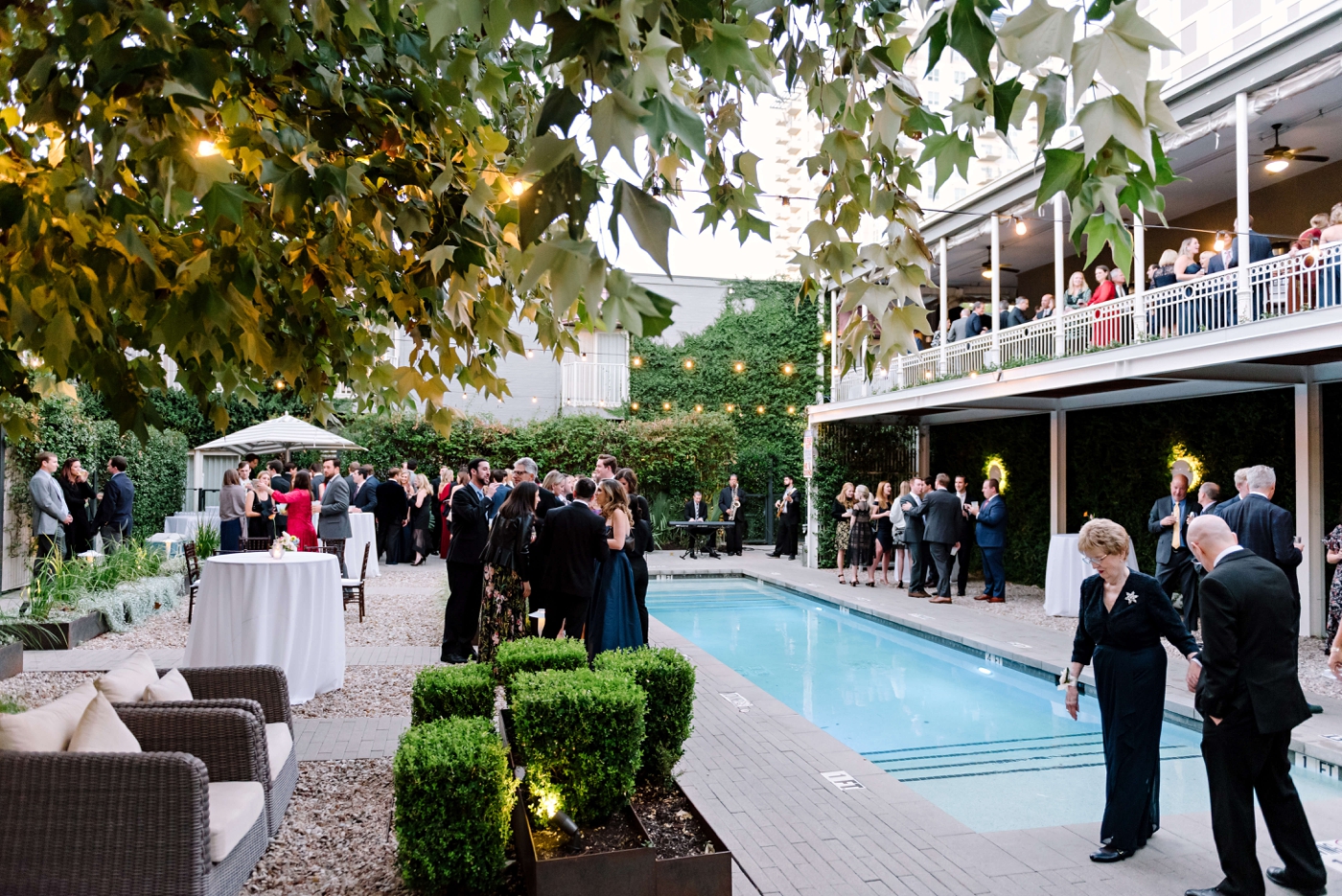 Wedding cocktail hour by a pool in downtown Austin, with guests eating at cocktail tables