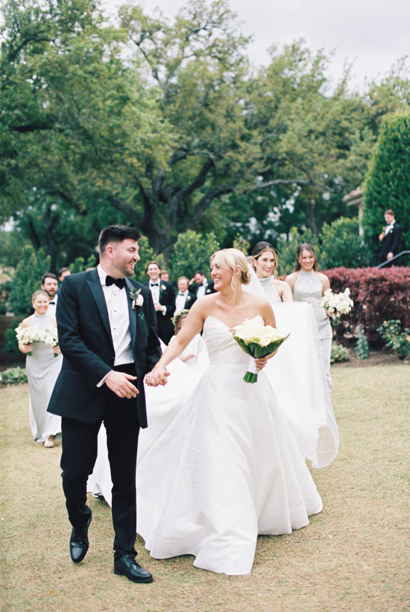 Bride and groom pictures at Austin Country Club, with their wedding party behind them