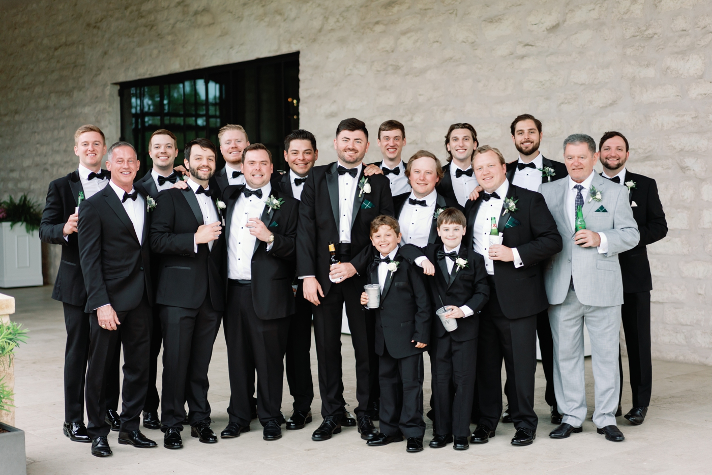 Groom and groomsmen getting ready before a wedding in Austin, wearing black suits