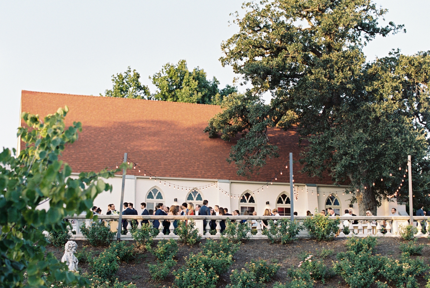 Cocktail hour on the Chapel Terrace at Commodore Perry Estate with guests mingling against the mansion backdrop.