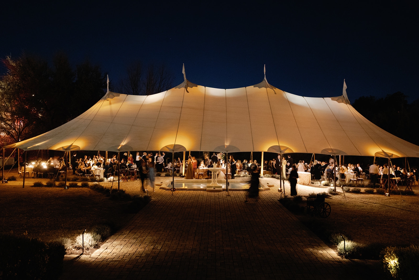 Evening view of a tent on the grounds of Commodore Perry Estate, with lighting 